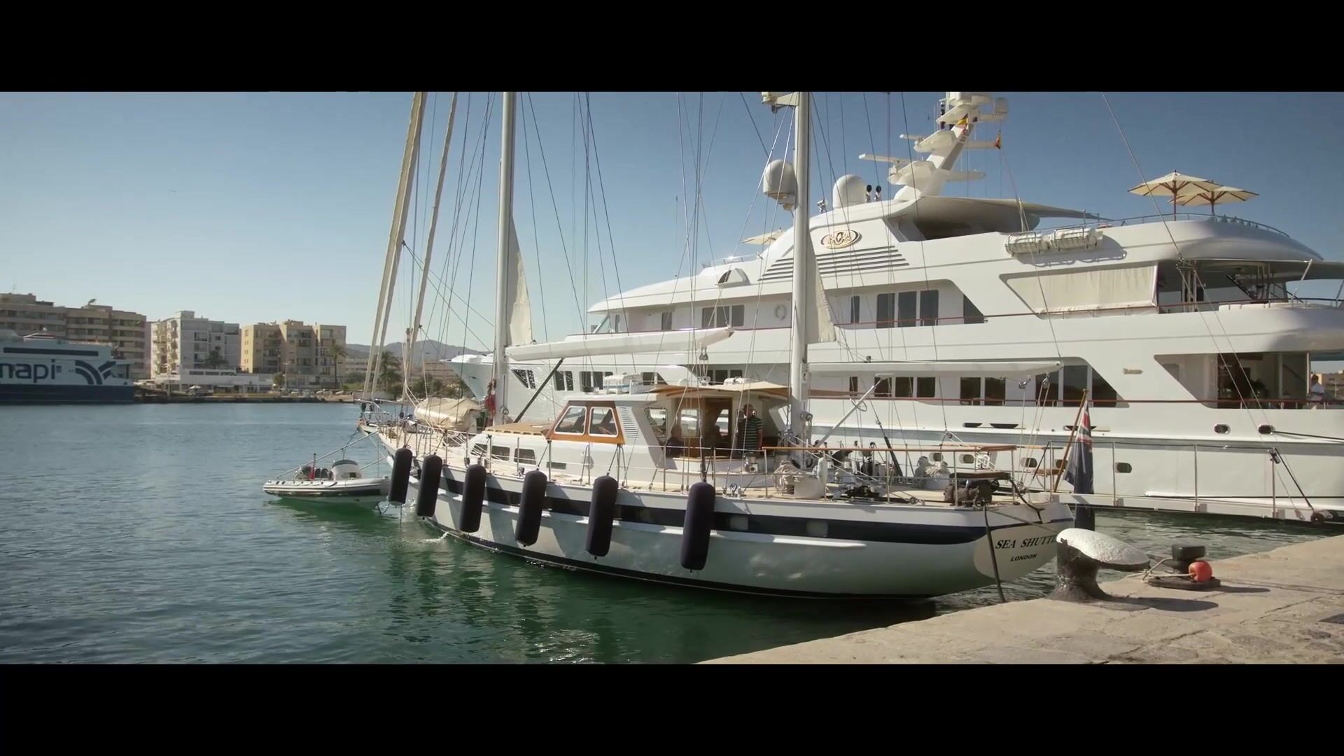Sailboat moored beside a yacht in Ibiza’s harbour